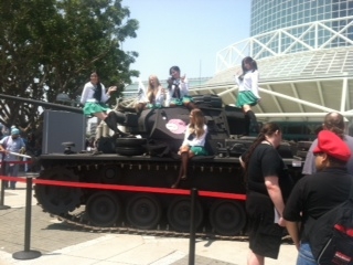 Cosplayers climb on a replica tank outside the convention center.